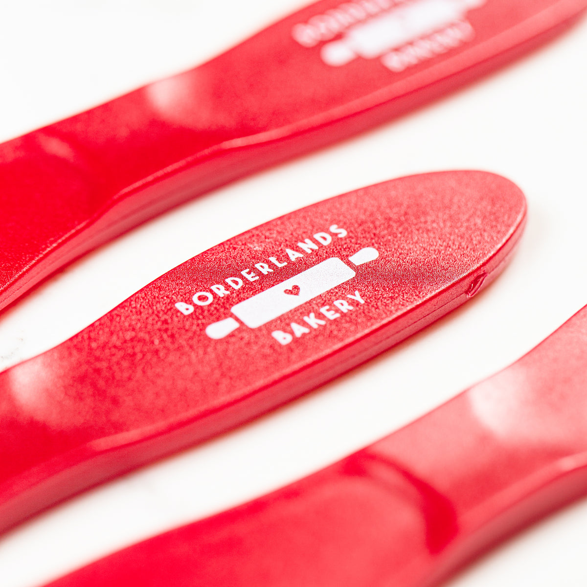 Small red polypropylene icing spatula by Borderlands Bakery