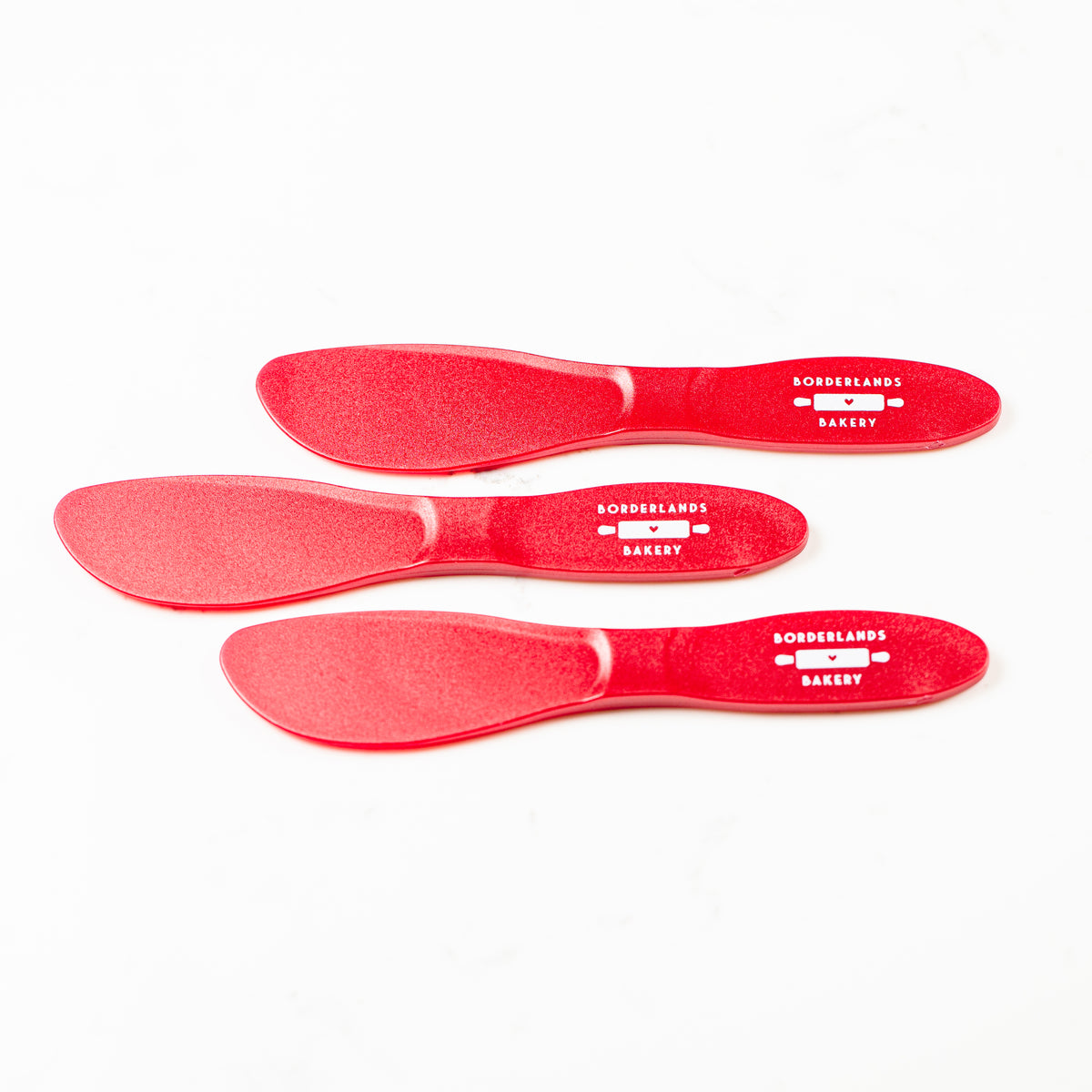 Small red polypropylene icing spatula by Borderlands Bakery
