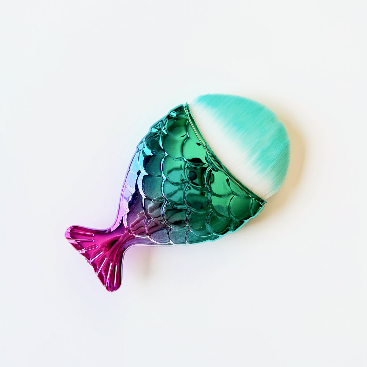 Mermaid tail shaped dusting brush with soft synthetic bristles, approximately 3 inches long