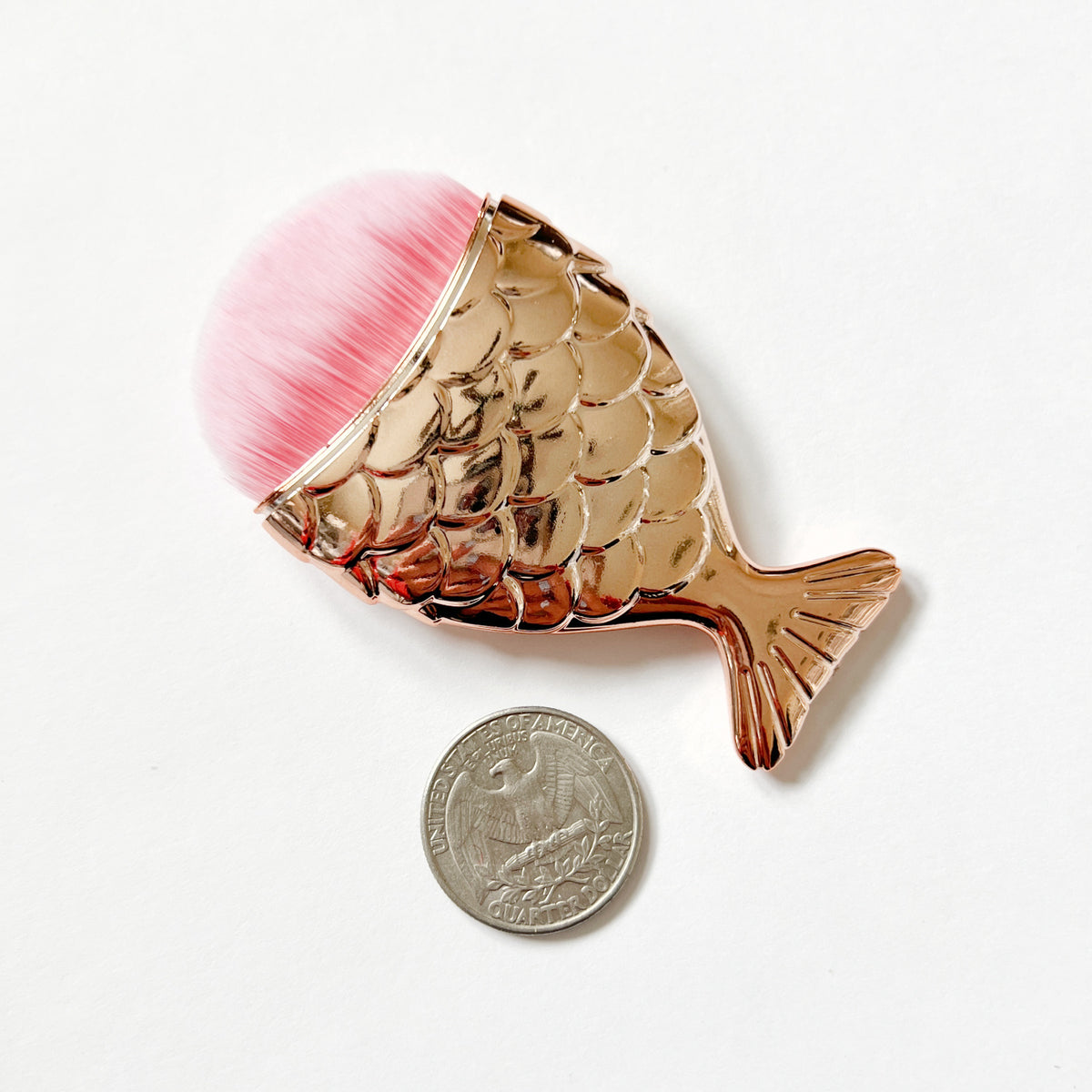 Mermaid tail shaped dusting brush with soft synthetic bristles, approximately 3 inches long